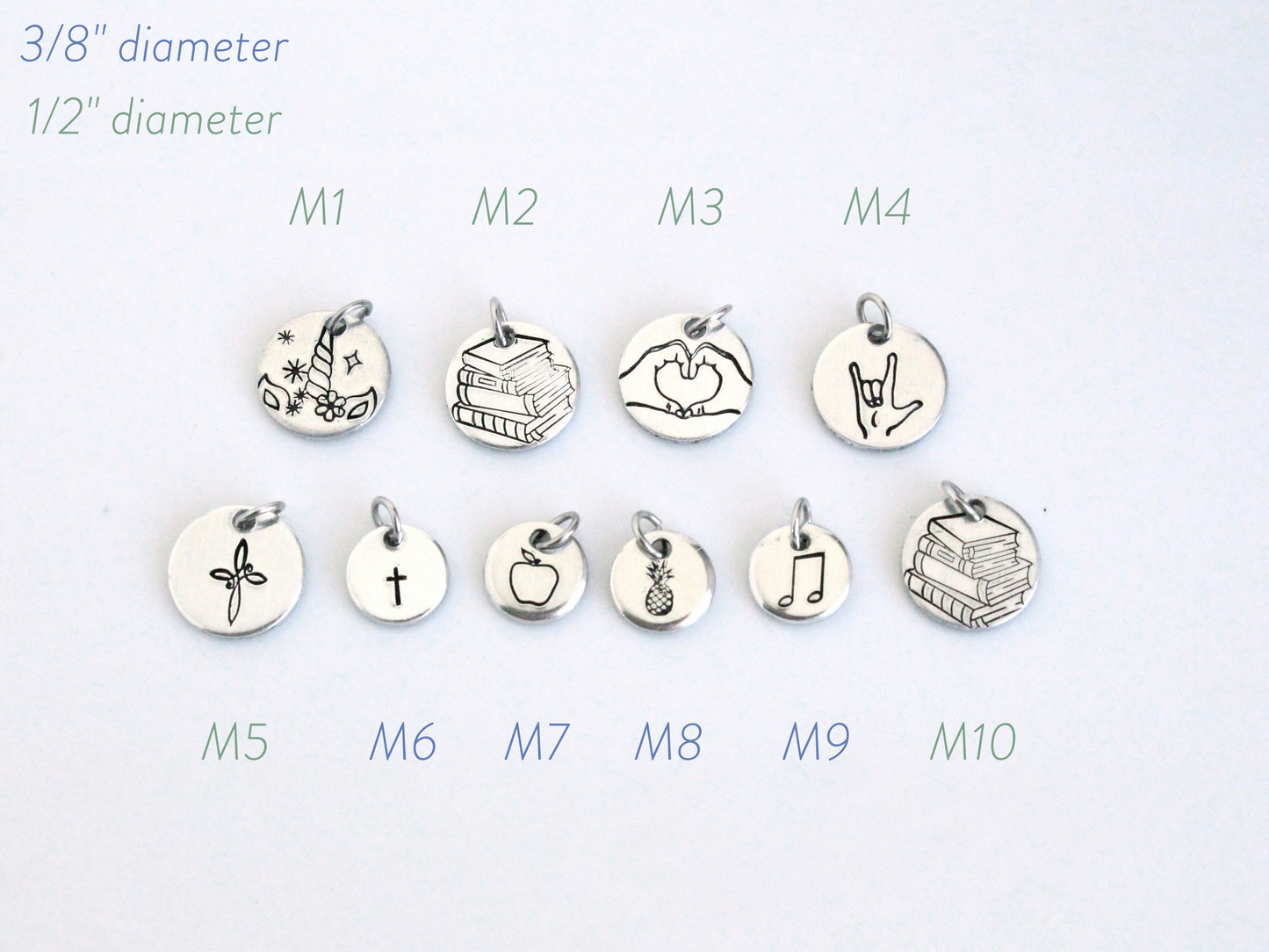 Set of silver charms with various designs on a white background