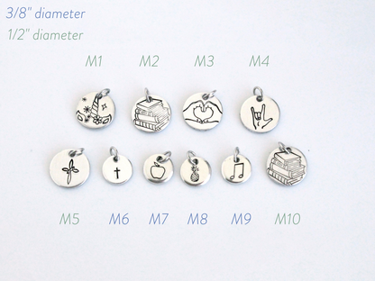 Set of silver charms with various designs on a white background