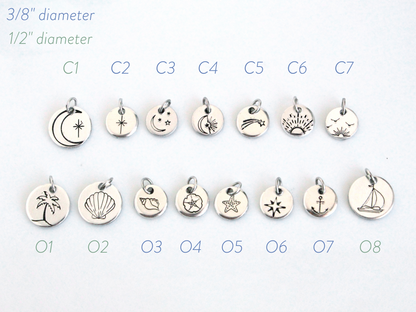 Set of silver charms with various designs on a white background