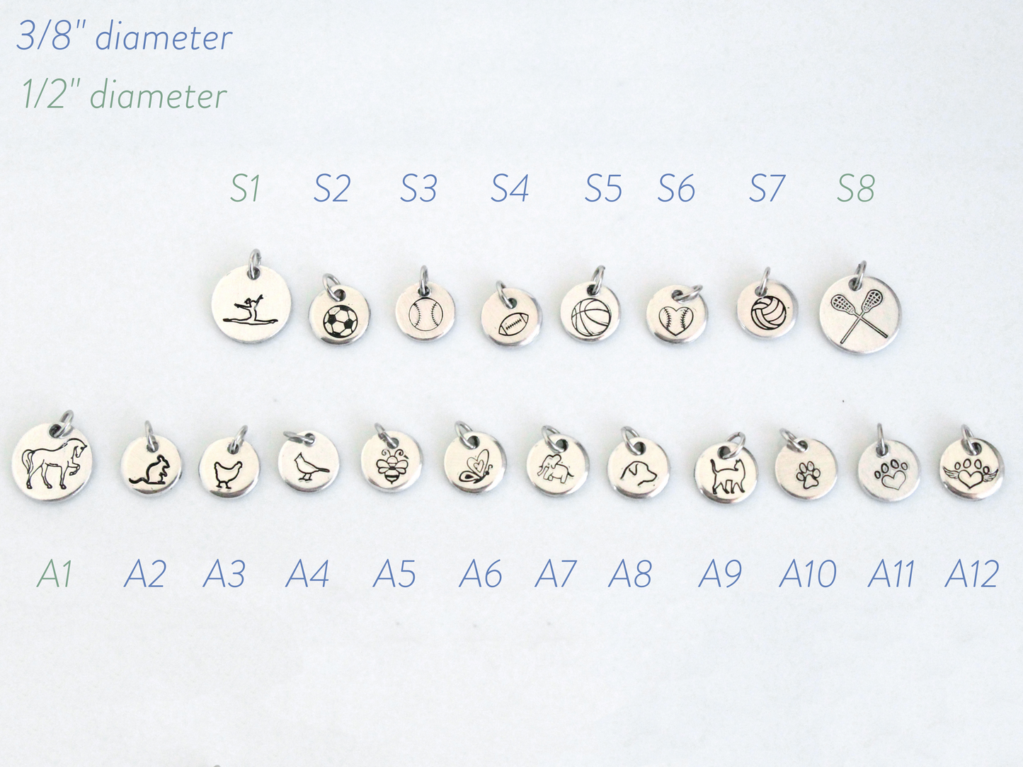 Set of small silver charms with various designs on a white background