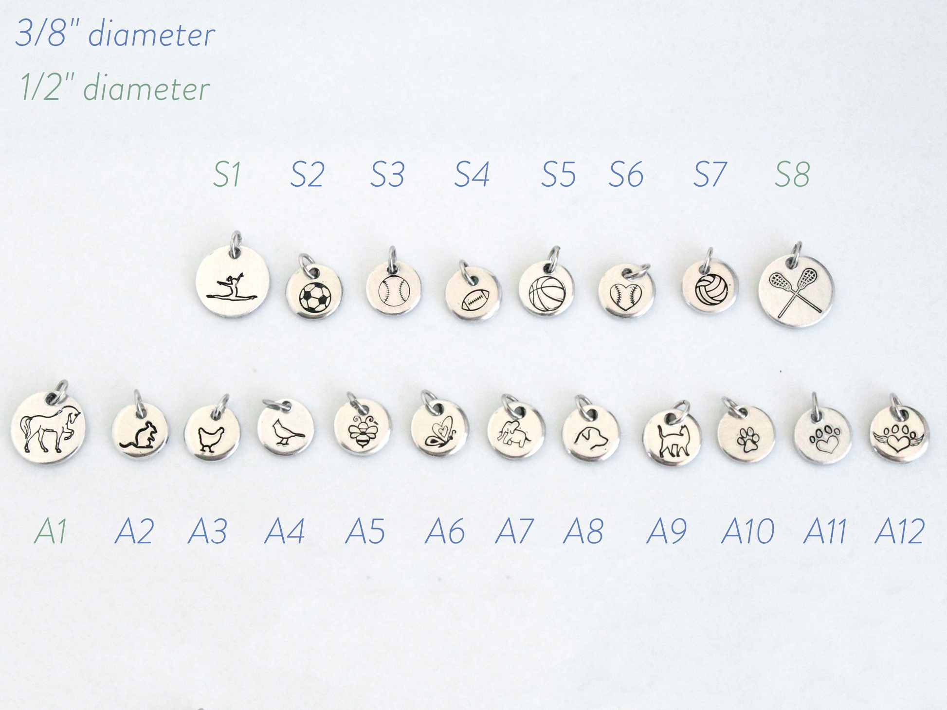 Set of small silver charms with various designs on a white background