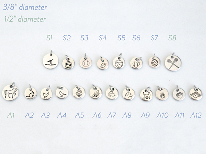 Set of small silver charms with various designs on a white background